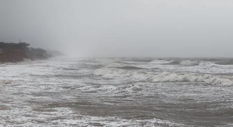 Dramatic Waves Crashing Against Rocky Beach Shore on a Cloudy Day. Stock-Fotos