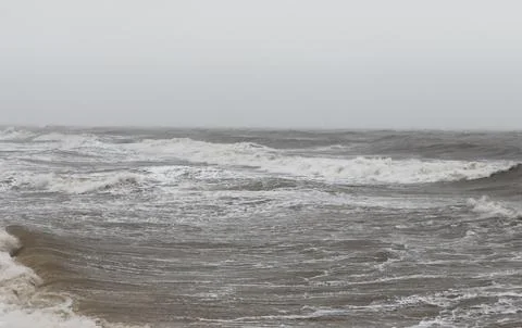 Dramatic Waves Crashing Against Rocky Beach Shore on a Cloudy Day. Stock-Fotos