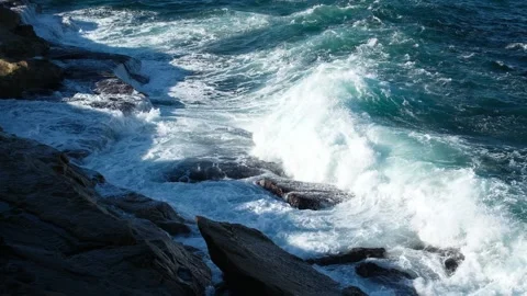 Dramatic waves crashing onto rocky shoreline with foamy white water Stock Footage 317815950