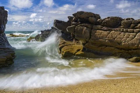 Dramatic waves hit rocky coast under a blue sky, Pistis, Arbus, province of Stock Photos
