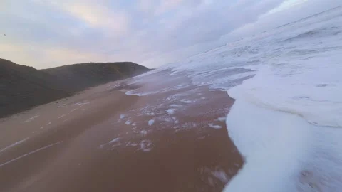Dramatic waves roll toward shore beneath cloudy sky Stock Footage 344673612