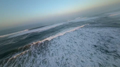 Dramatic waves roll toward shore at sunrise Vídeos de archivo 346168357