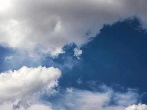Dramatic White and Gray Clouds Against Deep Blue Sky Stock Photos