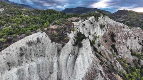 Dramatic White Cliffs and Pine Forest Under Storm Clouds Stock Footage 297252843