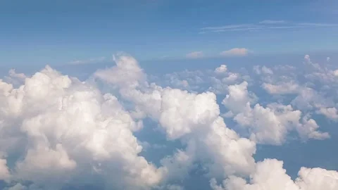 Dramatic white clouds and blue sky are visible from the airplane window Stock Footage 311308065