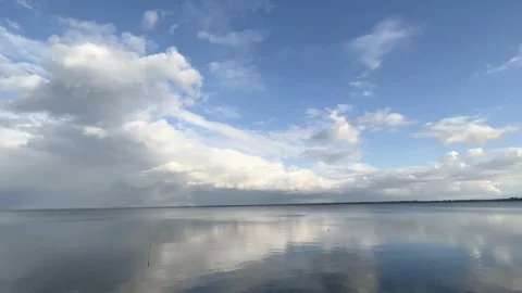 Dramatic white clouds form over a large placid lake in fall Stock Footage 273176518