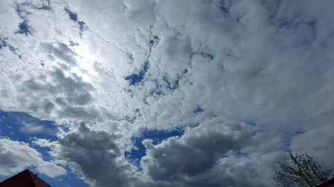 Dramatic white clouds moving across the blue sky with bright sun Stock Footage 334186189