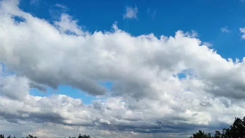 Dramatic White Clouds Moving Across a Bright Blue Summer Sky Stock Footage 340238737