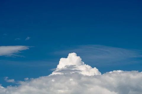 Dramatic white cumulus cloud rising beneath deep blue sky 写真素材