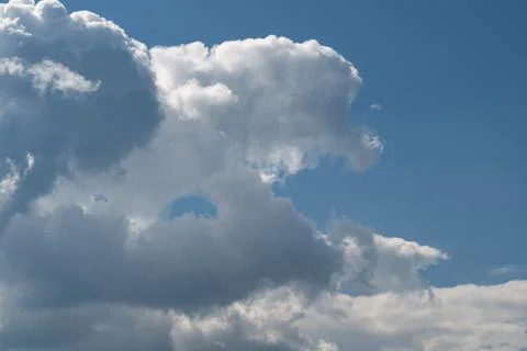 Dramatic white cumulus clouds against blue sky with soft sunlight Stock Photos
