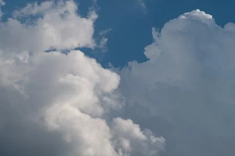 Dramatic white cumulus clouds against blue sky Stock Photos