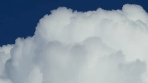 Dramatic white cumulus clouds billowing against deep blue sky, bold contrast Stock Footage 346377726