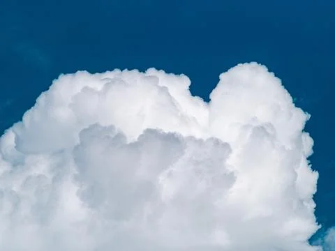Dramatic white cumulus clouds billowing against deep blue sky, bold contras.. Stock Photos