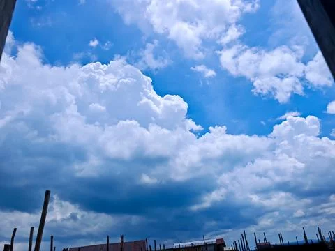 Dramatic White Cumulus Clouds over Coastal Stilt House Village Stock Photos