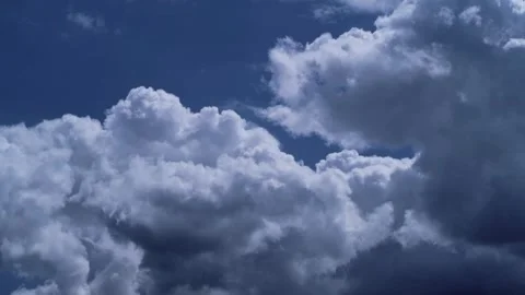 Dramatic white puffy clouds moving across a deep blue sky Stock Footage 332726475