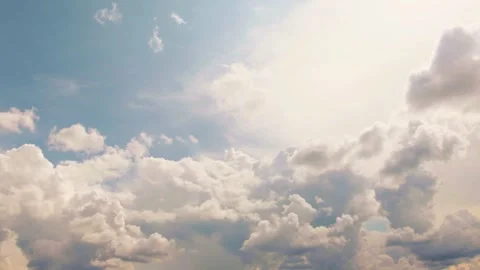 Dramatic white puffy clouds moving through a bright blue sky Stock Footage 332727483
