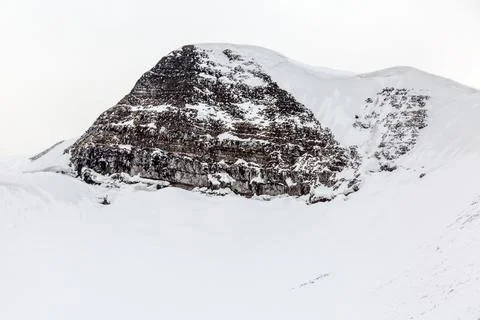 Dramatic winter landscape with a rugged mountain peak stands tall, covered .. Foto stock