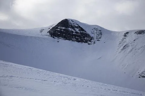 Dramatic winter landscape with a rugged mountain peak stands tall, covered .. Stock Photos