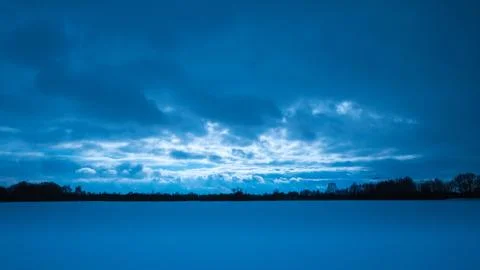 Dramatic winter landscape, snow, clouds, blue hour Stock Photos