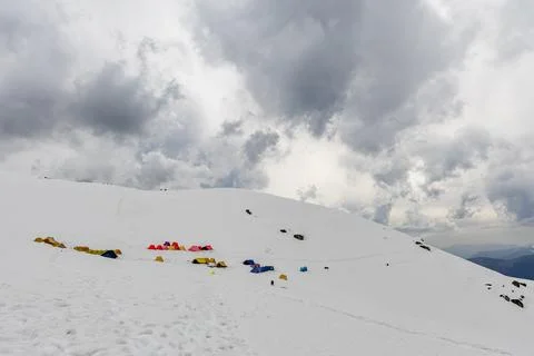Dramatic winter mountain camp with colorful tents on frozen himalayas under.. Fotos Stock