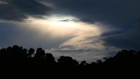 Dramatic winter sunset behind clouds, over the mountains. 4k  P1120634 Stock Photos