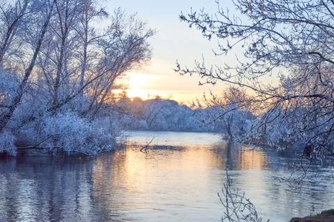 Dramatic winter sunset with the view of a river and everything frozen by the  Stock Photos