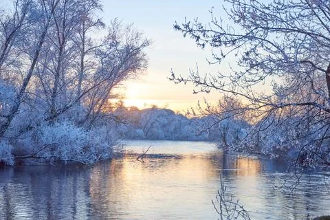 Dramatic winter sunset with the view of a river and everything frozen by the  Stock Photos