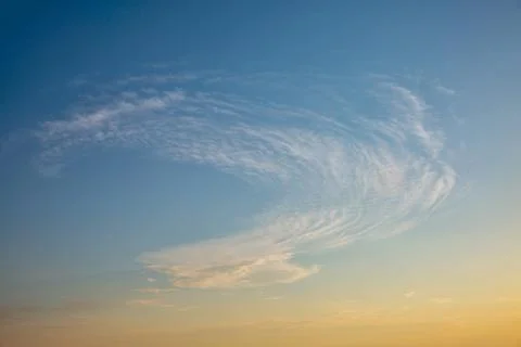 Dramatic wispy clouds in blue evening sky. Stock Photos