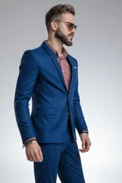 Dramatic young model in blue suit wearing sunglasses Stock Photos