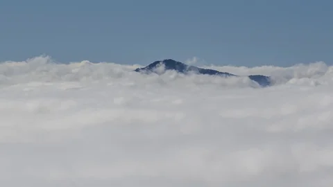 Dramatic zoom out time lapse over low altitude clouds inversion Stock Footage 128969220