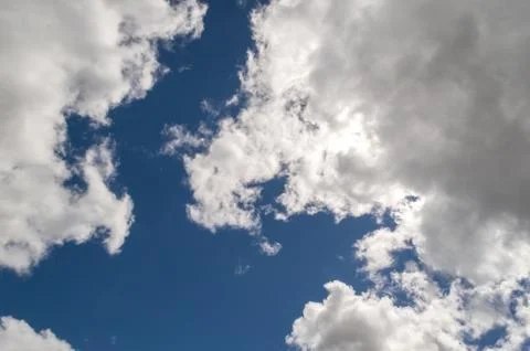 Dramatically illuminated billowy clouds brightly back lit, blue sky. Stock-Fotos