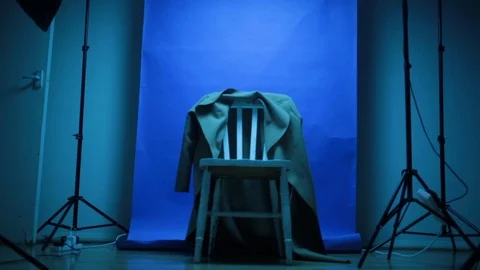 Dramatically lit chair in empty photo studio tracking slider shot Stock-Footage 98746041