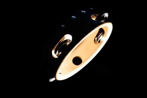 Dramatically Lit High Contrast Isolated Tambourine on Black Background Foto stock