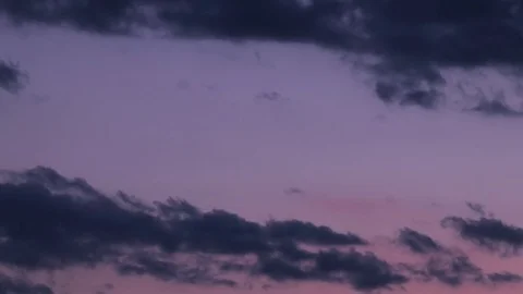 Dramatically lit storm clouds of pink, blue, orange, 4k Stock Footage 76455196