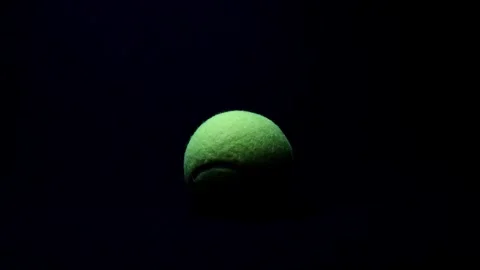Dramatically Lit Tennis Ball. Light Moving From Left to Right Stock Footage 249354181