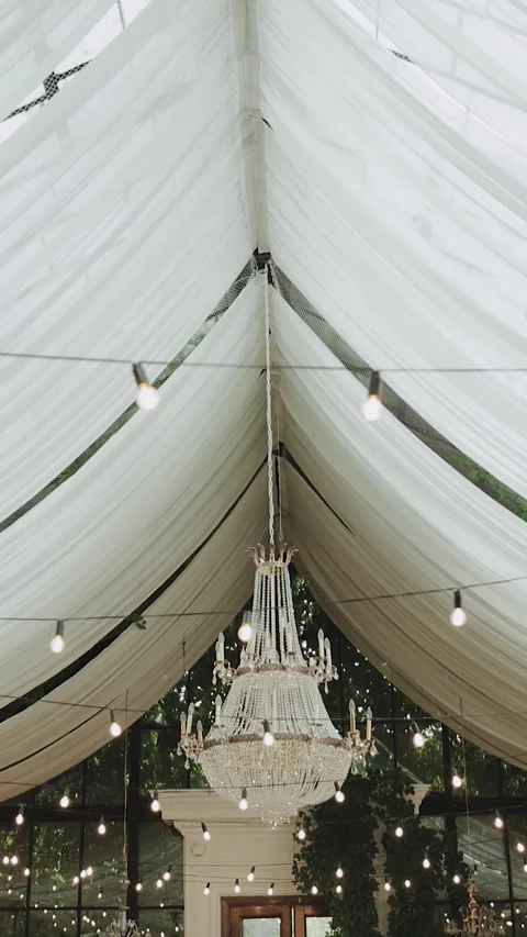 Draped ceilings and warm lights, Light bulbs garland and chandelier. Electric Stock Footage 306155912