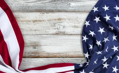 Draping US flag on bottom and side borders of white rustic wooden background Stock Photos