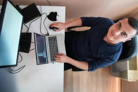 Draufsicht auf einen Programmierer, der in seinem Büro sitzt und fleißig S. Stock-Fotos