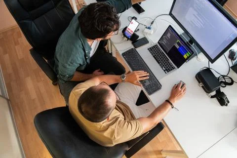 Draufsicht auf einen Programmierer, der in seinem Büro sitzt und fleißig S. Foto stock