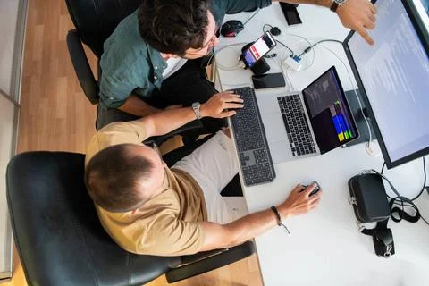 Draufsicht auf einen Programmierer, der in seinem Büro sitzt und fleißig S. Stock Photos