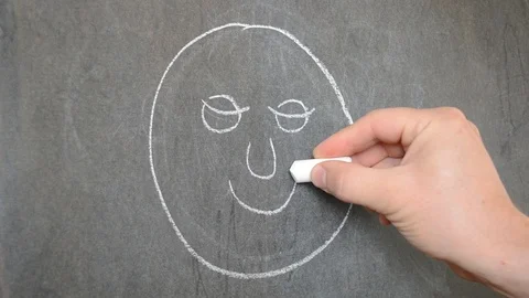Draw on the blackboard with chalk. Draw a face. Stock Footage 113691391