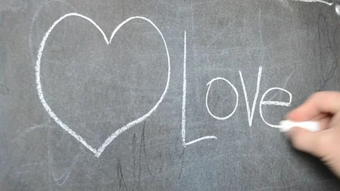 Draw on the blackboard with chalk. We draw a heart. Stock Footage 113692270