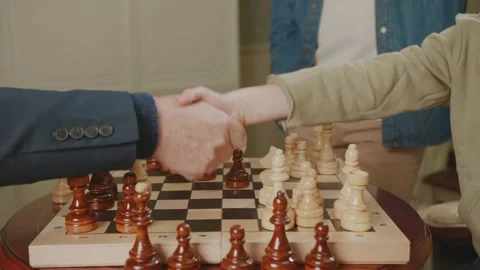 Draw in chess game. Players shake hands over chessboard. Stock Footage 235014990