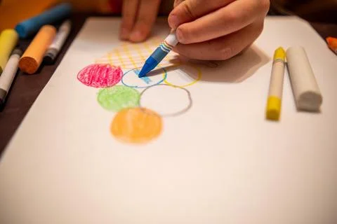 Draw with colored pencils on a white sheet of paper. Stock Photos