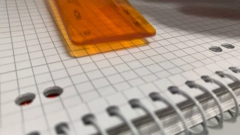 Draw lines with a ruler on a piece of paper in a notepad Stock Footage 123856926