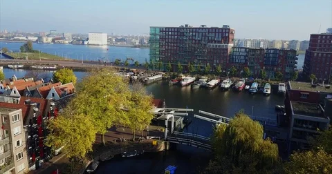 Drawbridge and moored barges below red brick waterfront flats Vídeo Stock 71295287