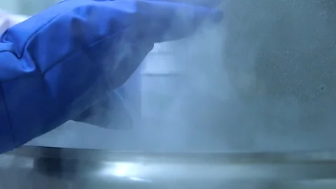 Drawer being removed from liquid nitrogen cryogenic cold storage - Stock Footage 92607499