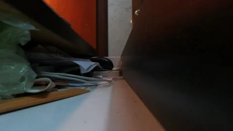 A drawer opens and a man's hand puts a stack of hundred-dollar bills, a pho.. Stock Footage 258417355