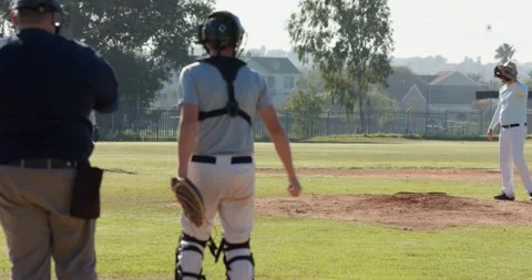Drawing arm back after umpire signal male pitcher lifting leg and throwing Stock Footage 344644085