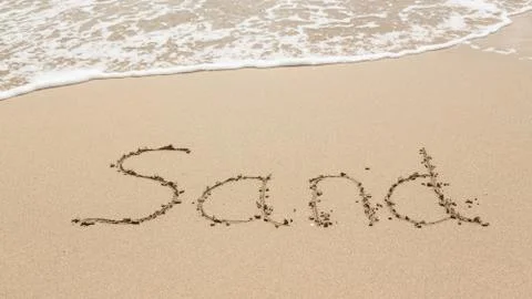 Drawing in beach by ocean of sand word Stock Photos